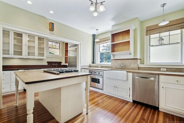 kitchen featuring a breakfast bar, pendant lighting, appliances with stainless steel finishes, and white cabinets