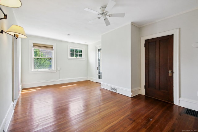 unfurnished room with ceiling fan, dark hardwood / wood-style flooring, and ornamental molding