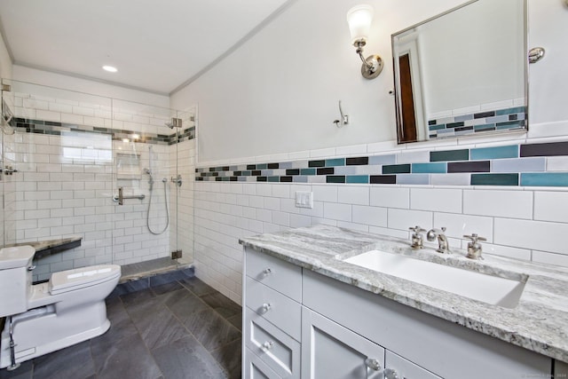 bathroom featuring toilet, tiled shower, tile patterned flooring, tile walls, and vanity