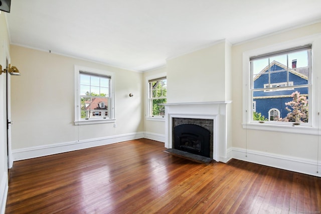 unfurnished living room featuring wood-type flooring, ornamental molding, and a fireplace