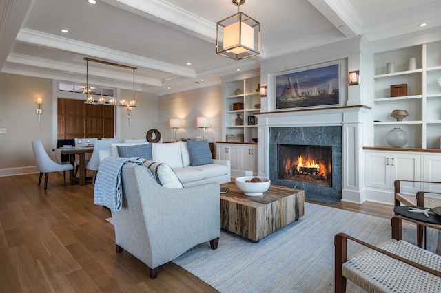 living room featuring beamed ceiling, hardwood / wood-style floors, a high end fireplace, and crown molding