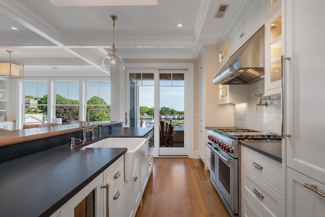 kitchen with light hardwood / wood-style floors, tasteful backsplash, double oven range, decorative light fixtures, and white cabinets