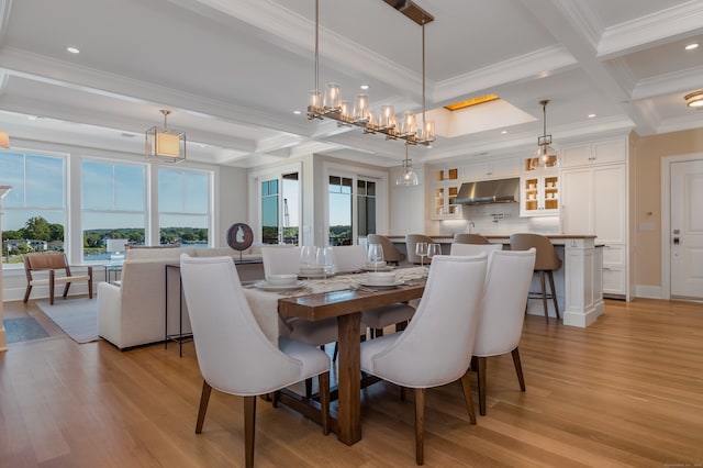 dining room with beam ceiling, crown molding, and light hardwood / wood-style flooring