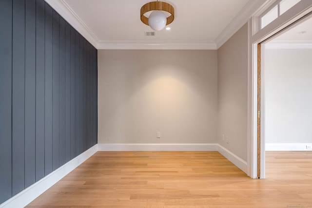 spare room featuring light hardwood / wood-style flooring and crown molding