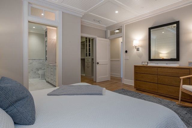 bedroom featuring ensuite bathroom, light wood-type flooring, and ornamental molding