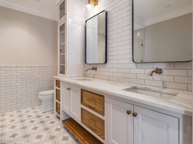 bathroom featuring double vanity, tile walls, toilet, tile flooring, and ornamental molding