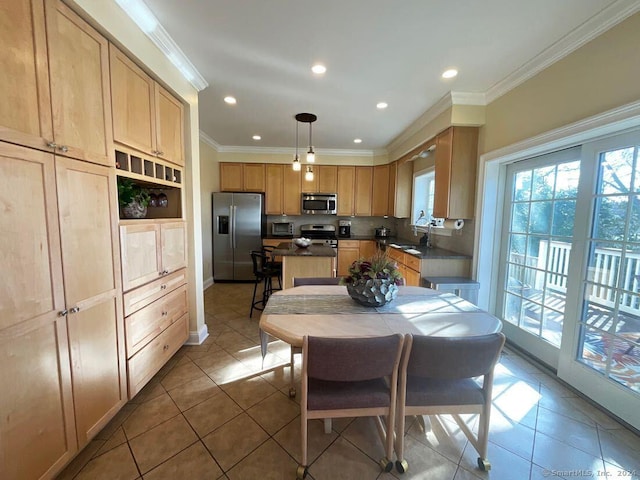 kitchen featuring sink, crown molding, appliances with stainless steel finishes, light brown cabinetry, and decorative light fixtures