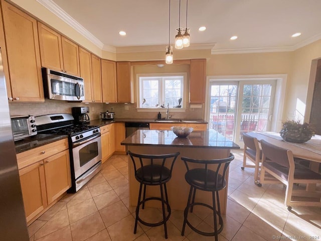 kitchen featuring stainless steel appliances, a kitchen island, backsplash, and light brown cabinetry