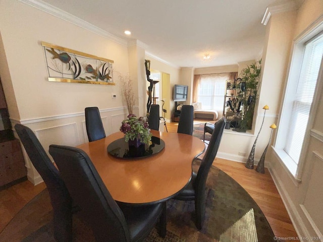 dining area featuring crown molding and light hardwood / wood-style flooring