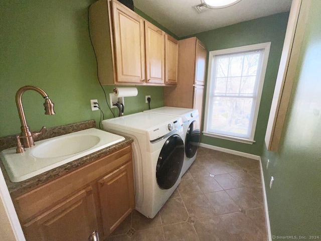 washroom with sink, tile patterned floors, cabinets, and washer and dryer