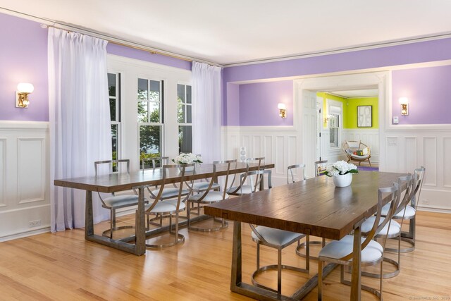 dining room featuring light hardwood / wood-style flooring and crown molding