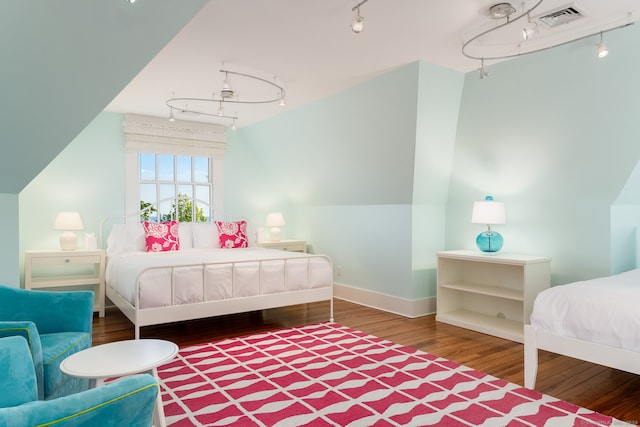 bedroom featuring hardwood / wood-style floors and rail lighting