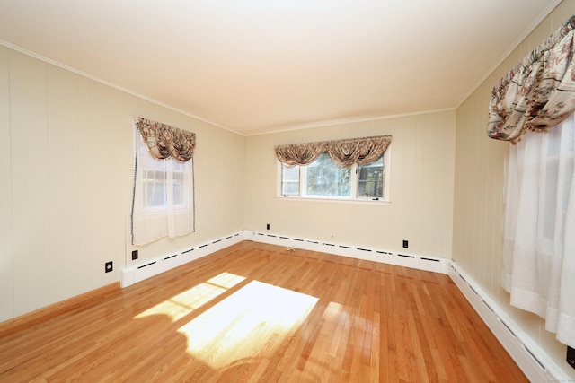 unfurnished room featuring a baseboard radiator, hardwood / wood-style flooring, and crown molding