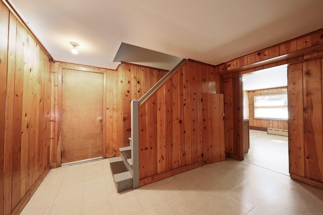 hall with wood walls and a baseboard radiator