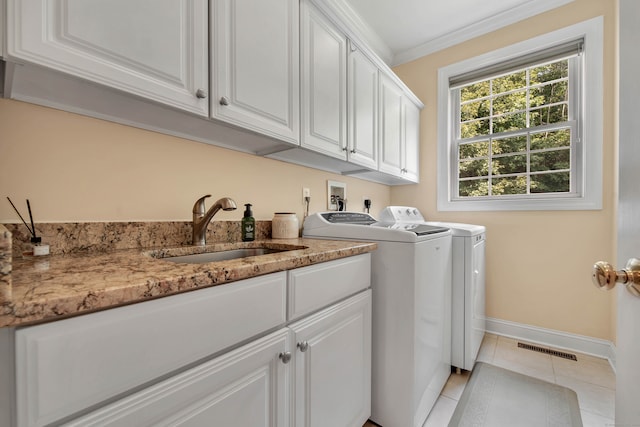 washroom featuring light tile patterned floors, sink, cabinets, separate washer and dryer, and crown molding