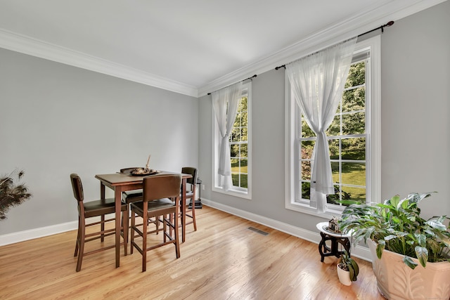 dining area with crown molding, light hardwood / wood-style flooring, and a wealth of natural light