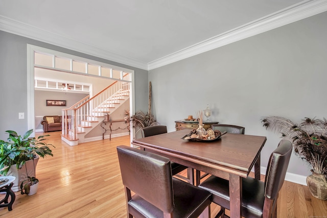 dining area with ornamental molding and light hardwood / wood-style flooring