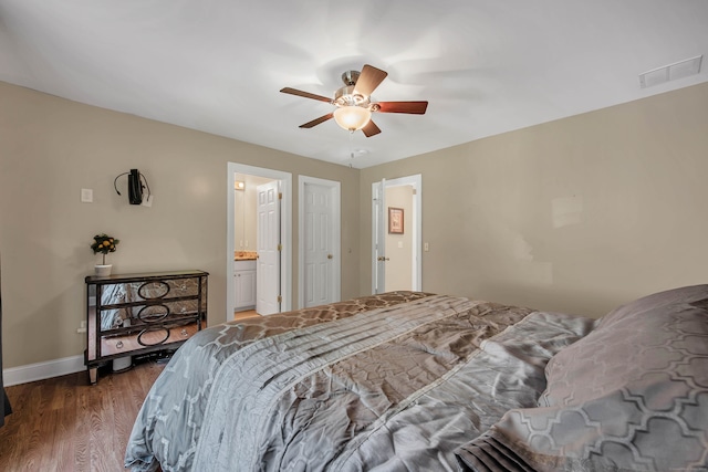 bedroom featuring ceiling fan, hardwood / wood-style flooring, and ensuite bath