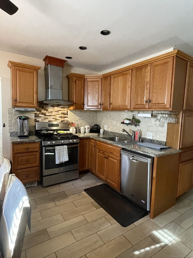 kitchen with sink, stainless steel appliances, decorative backsplash, and wall chimney exhaust hood