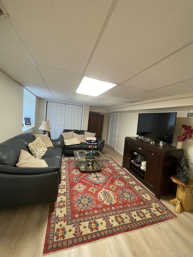 living room with light hardwood / wood-style floors and a paneled ceiling