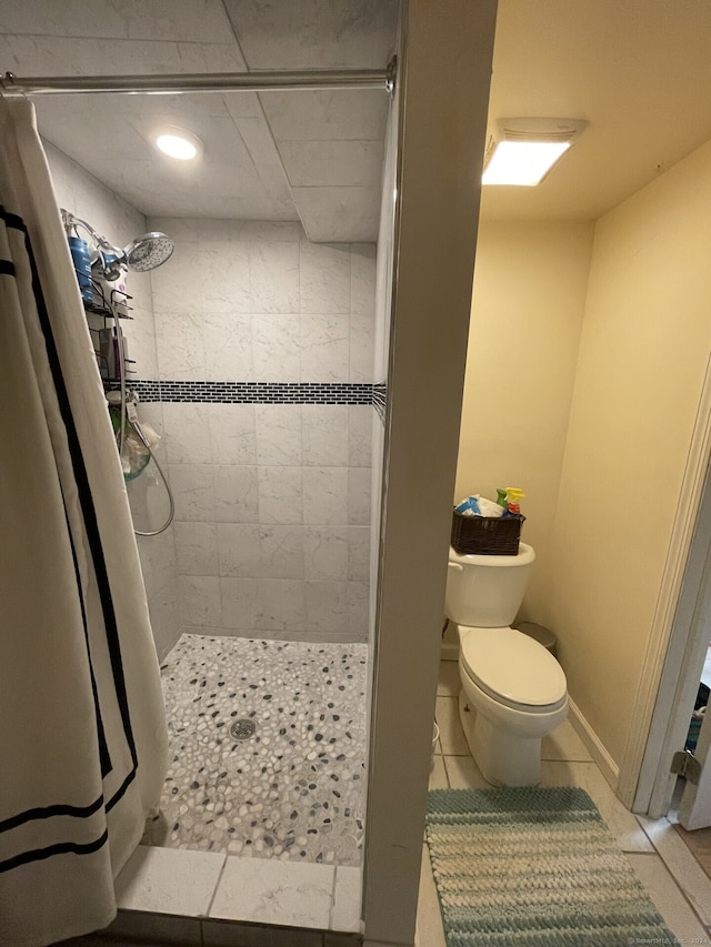 bathroom featuring tile patterned flooring, curtained shower, and toilet