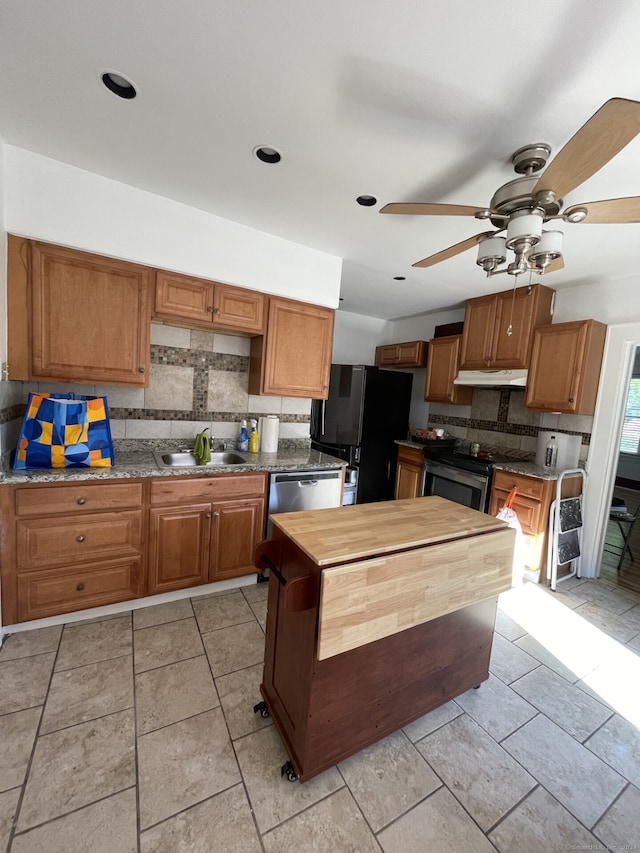 kitchen with light tile patterned floors, backsplash, appliances with stainless steel finishes, and ceiling fan