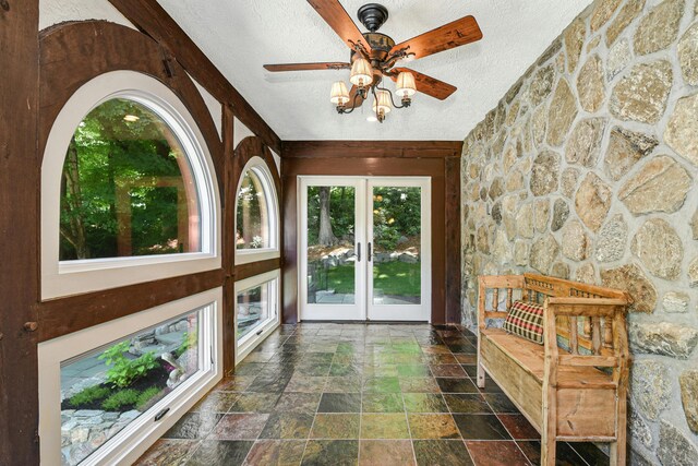 hallway with a textured ceiling and dark tile patterned flooring