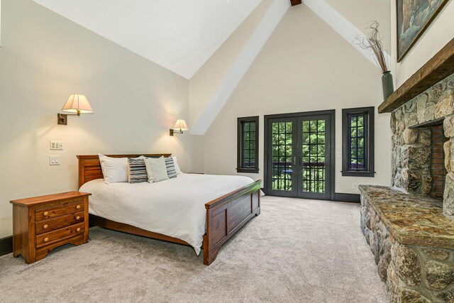 carpeted bedroom featuring access to exterior, a fireplace, french doors, and vaulted ceiling