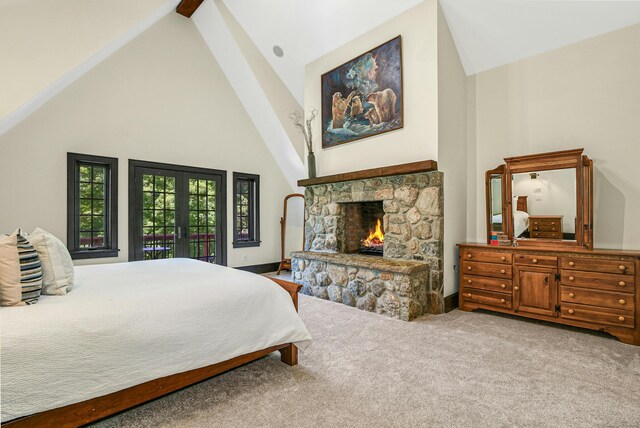 bedroom featuring a stone fireplace, french doors, carpet floors, and high vaulted ceiling