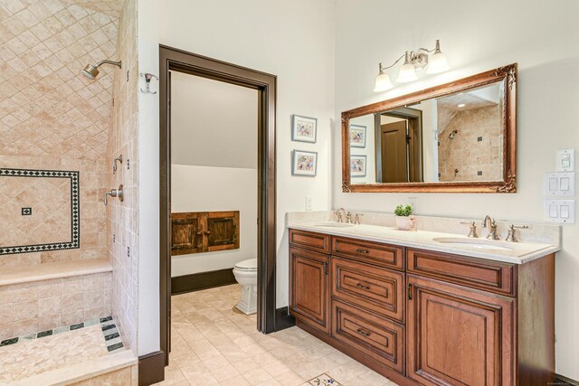 bathroom with toilet, tile patterned floors, and double sink vanity