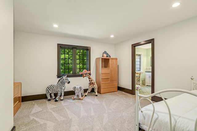 bedroom featuring ensuite bath and carpet