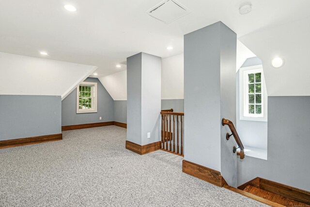 bonus room featuring light carpet and vaulted ceiling