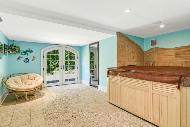 kitchen featuring light tile patterned flooring, light brown cabinets, and french doors