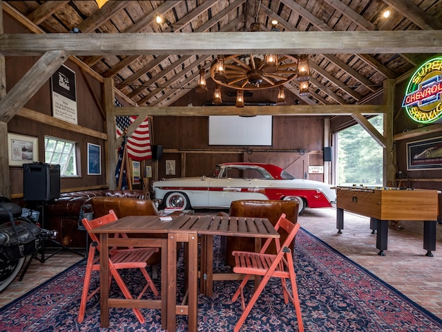 dining space with high vaulted ceiling, wooden ceiling, and wood walls