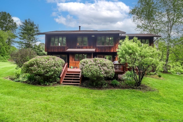 back of property featuring a wooden deck and a yard