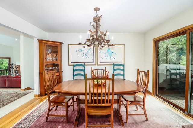 dining area with wood-type flooring and an inviting chandelier