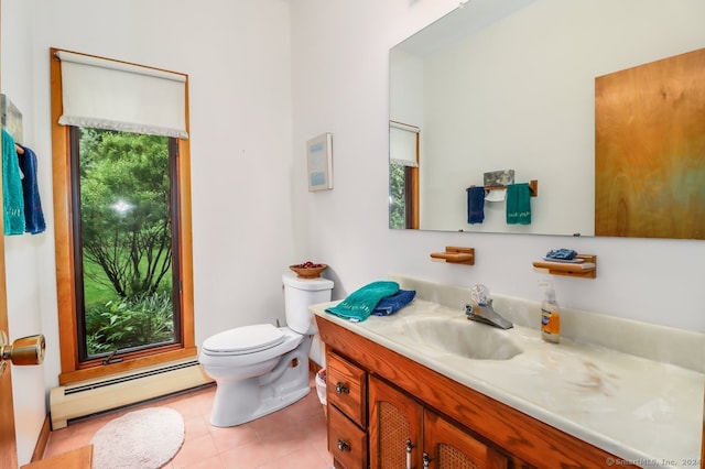 bathroom featuring baseboard heating, a wealth of natural light, vanity, and toilet