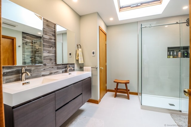 bathroom featuring decorative backsplash, a skylight, tile patterned floors, walk in shower, and vanity