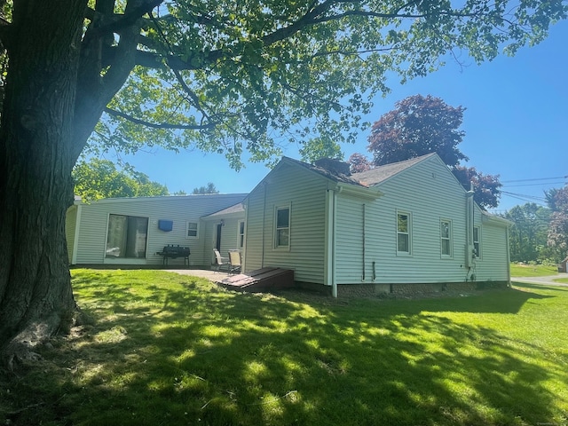 rear view of property featuring a patio area and a lawn