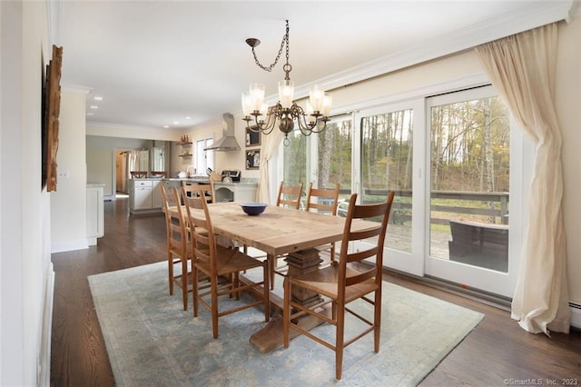 dining room with crown molding, dark wood-type flooring, and a chandelier