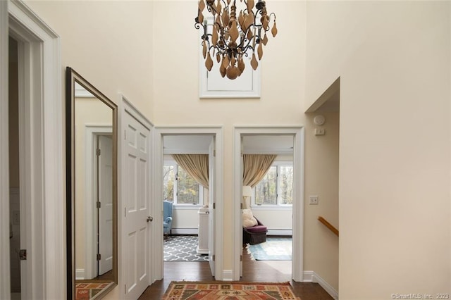 entryway featuring an inviting chandelier, a baseboard radiator, and dark hardwood / wood-style floors