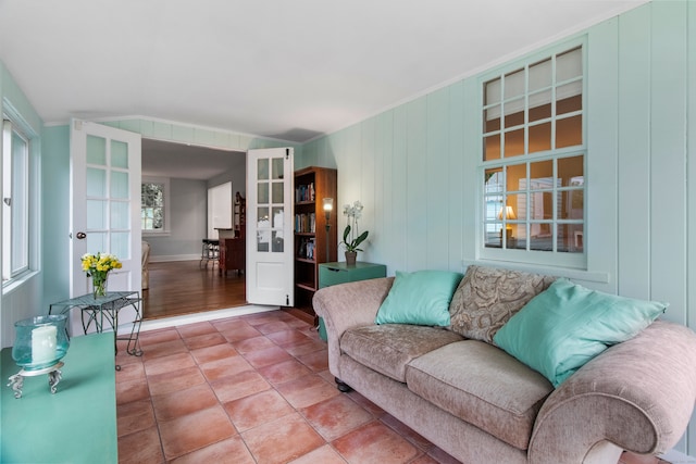 tiled living room with crown molding and vaulted ceiling