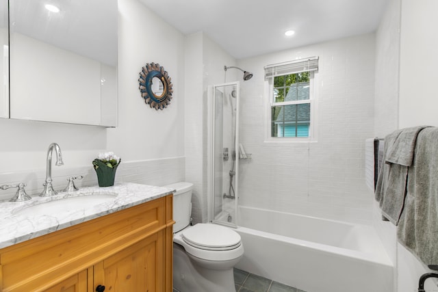 full bathroom with tiled shower / bath, vanity, toilet, and tile patterned floors