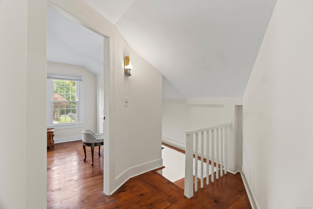 stairway featuring lofted ceiling and hardwood / wood-style floors