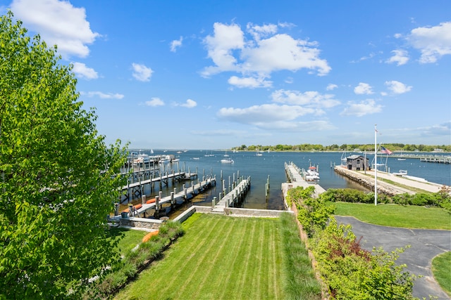 dock area with a lawn and a water view