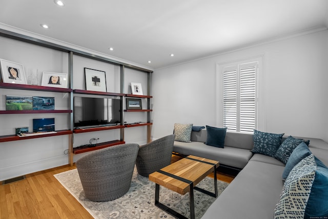 living room featuring ornamental molding and light hardwood / wood-style flooring