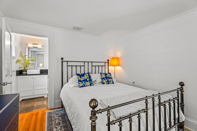 bedroom featuring ornamental molding and hardwood / wood-style floors