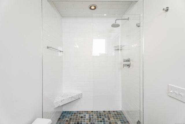 bathroom with a shower with door and toilet