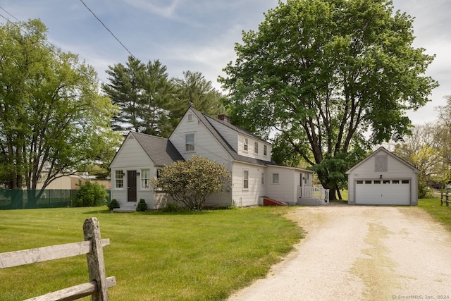 view of front facade featuring a garage, a front yard, and an outdoor structure