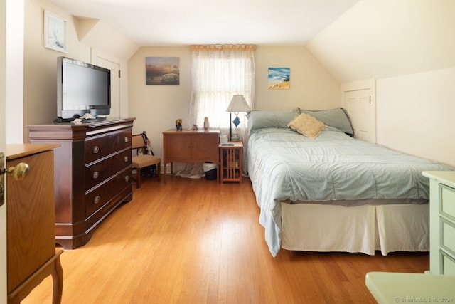 bedroom with wood-type flooring and vaulted ceiling